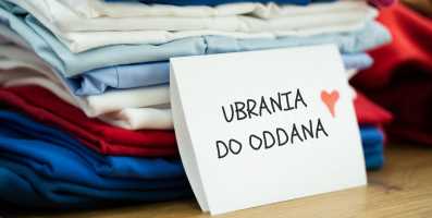 ubrania-do-oddania stos poskładanych ubrań z kartką podpisaną "ubrania do oddania i czerwonym serduszkiem